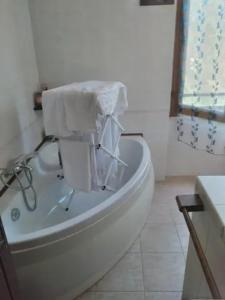 Sardinia Home Flat 4 beds in Carbonia في كاربونيا: حوض استحمام أبيض في حمام أبيض