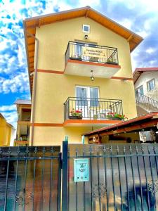 a building with balconies and a fence in front of it at PENSIUNEA SCOICA in Costinesti