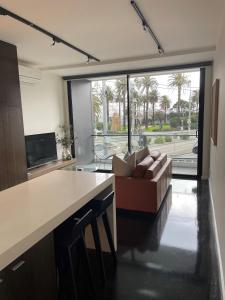 a living room with a couch and a large window at Heart of St Kilda in Melbourne