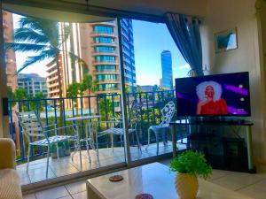 a living room with a balcony with a flat screen tv at WAIKIKI 2 BEDROOMS, 1 BATH, FREE PARKING, SLEEP 6 in Honolulu