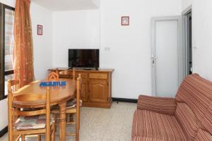 a living room with a table and a tv and a couch at Estirpe, 2º-3 in Cullera