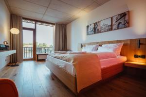 a bedroom with a large bed and a balcony at SeeLoge Eutin in Eutin