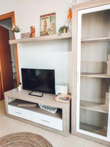 a living room with a tv on a wooden table at Nina's Blue Pool & Beach in Deltebre