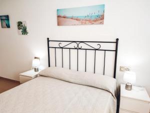 a bed in a bedroom with two night stands and two lamps at Nina's Blue Pool & Beach in Deltebre +76 photos