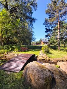 eine Holzbrücke über einen Bach in einem Park in der Unterkunft Wierzbowy Jar - Natura Spokój Sauna Kominek Karkonosze in Janowice Wielkie