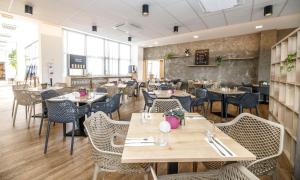 a restaurant with tables and chairs in a room at OREA Resort Santon Brno in Brno