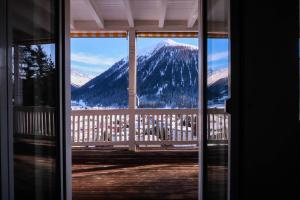 a view of a snowy mountain from a window at Davos Youth Hostel in Davos