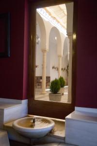 La salle de bains est pourvue d'un lavabo et d'un grand miroir. dans l'établissement Villa Turística de Priego, à Priego de Córdoba