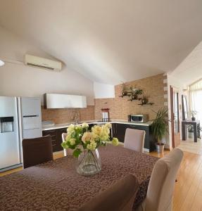a kitchen with a table with a vase of flowers on it at Villa Nora in Tučepi
