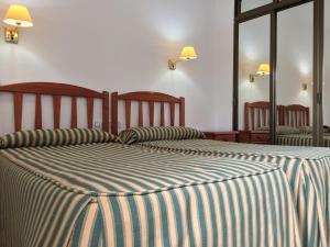 A bed or beds in a room at Hotel Atalayas Zafra