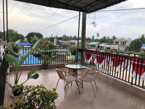 a patio with a table and chairs on a balcony at Inalum Permata Guest House 