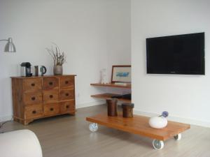 a living room with a tv and a wooden table at Quinta de Santa Clara in Ponta Delgada
