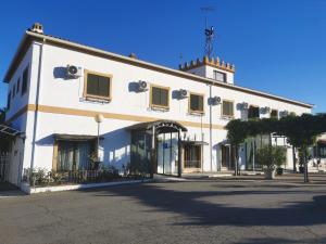 a large white building with windows on a street at Hotel Atalayas Extremadura in Zafra