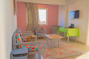 a living room with a table and chairs and a table and a green table at فندق الشاطئ رأس البر-Beach Hotel Ras Elbar in Ras El Bar