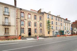 uma rua vazia em frente a um grande edifício em Le Beaumont em Rennes