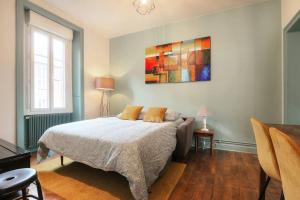 a bedroom with a bed and a painting on the wall at Le Beaumont in Rennes