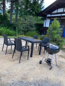 a picnic table and chairs with a grill and a bbq at 1日1組限定-伊那谷別邸-share old folk house- in Ina