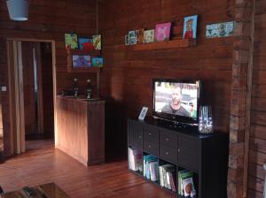 een woonkamer met een televisie en een boekenplank bij Casa de madera in A Coruña
