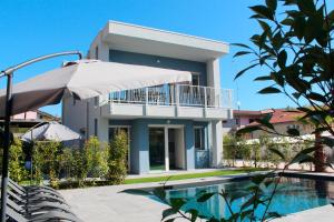 a house with a swimming pool in front of a house at Villa Karolina Luxury Pool Villa Desenzano del Garda in Desenzano del Garda