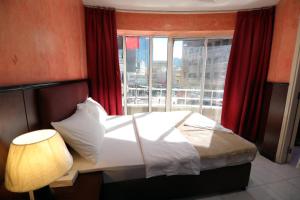 a bedroom with a bed and a large window at OYO 912 Tanha Hotel in Dubai