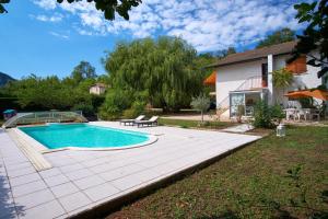 a swimming pool in a yard next to a house at Villa De Marchi in Saint-Just-de-Claix