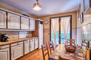 cocina con mesa, sillas y ventana en Villa De Marchi, en Saint-Just-de-Claix