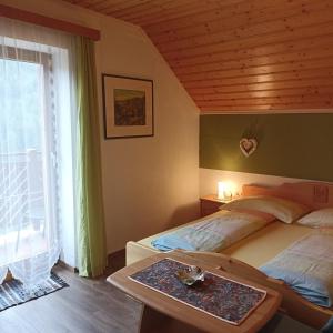 a bedroom with two beds and a large window at Ferienhaus Gstoderblick in Seebach