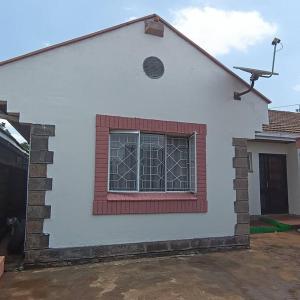 a white house with a window on the side of it at Walk to Strathmore Uni, Java, Wilson Airport,tmall in Nairobi