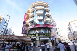 a tall building with people walking in front of it at OYO 912 Tanha Hotel in Dubai