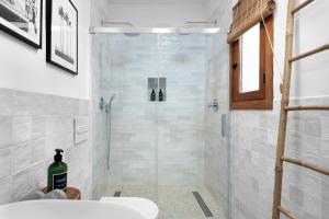 a bathroom with a shower with a glass door at La AMARA Zaid - en el casco antiguo de Frigiliana in Frigiliana +11 photos