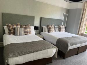 a bedroom with two beds and two nightstands at Ambleside Townhouse in Ambleside