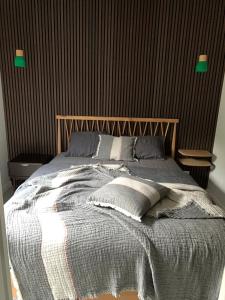 - une chambre avec un grand lit et une tête de lit en bois dans l'établissement Osbos chalets, à Lille