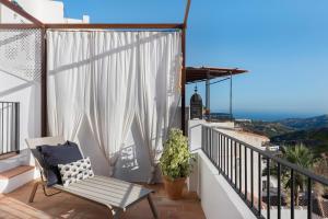 a balcony with a chair and a view of the ocean at La AMARA Zaid - en el casco antiguo de Frigiliana in Frigiliana