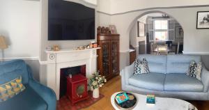 uma sala de estar com duas cadeiras azuis e uma lareira em Park View em Chester