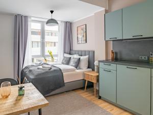 a small bedroom with a bed and a kitchen at limehome Salzgitter A.-Schweitzer-Str. in Salzgitter