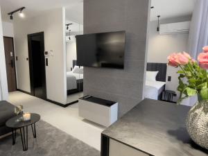 una sala de estar con TV y una habitación con 2 camas en URBAN APARTMENTS PREMIUM DOWNTOWN Opolska 10 No 69 with GARAGE, en Katowice