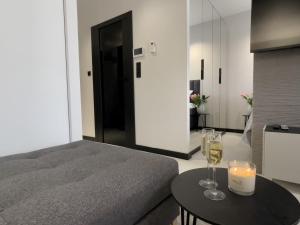 a bedroom with a bed and a table with wine glasses at URBAN APARTMENTS PREMIUM DOWNTOWN Opolska 10 No 69 with GARAGE in Katowice