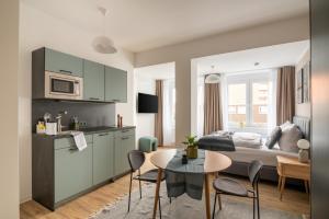 a kitchen and a living room with a table and chairs at limehome Salzgitter A.-Schweitzer-Str. in Salzgitter