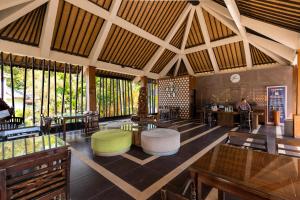 a large lobby with tables and chairs and windows at Full Moon Villa Ubud in Ubud