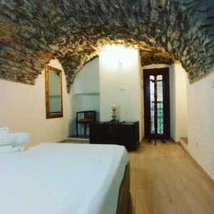 - une chambre avec un lit et un mur en pierre dans l'établissement Appartamento incantevole La Grotta, à Apricale