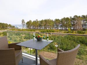 ein Tisch mit einer Vase mit Blumen auf einem Balkon in der Unterkunft Dünenresidenz Prora - Ferienwohnung mit Meerblick, 1 Schlafzimmer und Balkon NP-312 in Binz