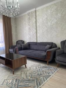 a living room with a couch and a coffee table at KERUEN SARAY APARTMENTS 27/2 in Türkistan