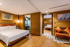 a bedroom with a bed and a chair in a room at Son Hoi An Boutique Hotel & Spa in Hoi An