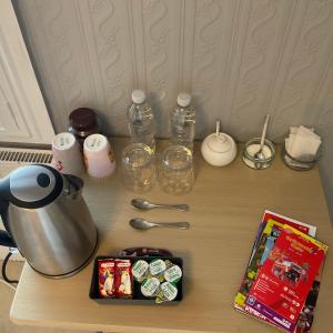 a table with a tea pot and bottles and a magazine at Park View in Chester