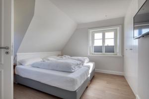Łóżko lub łóżka w pokoju w obiekcie Rantum Dorf - Ferienappartments im Reetdachhaus 3 & 4