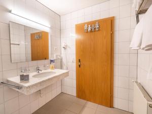 a bathroom with a sink and a wooden door at Group Apartment in Stubaital with Ski Storage in Neustift im Stubaital