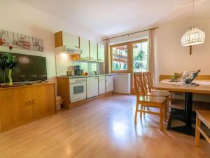 a kitchen with a table and a dining room at Group Apartment in Stubaital with Ski Storage in Neustift im Stubaital