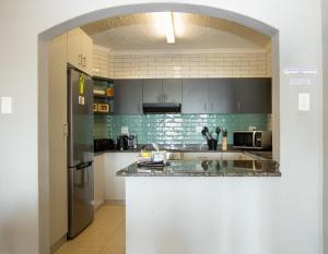 a kitchen with a counter and a refrigerator at The Bay 4 in Ballito