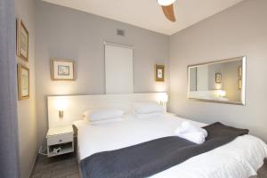 a bedroom with a white bed and a mirror at The Bay 4 in Ballito