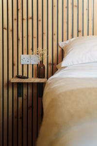 um quarto com uma cama e uma parede de madeira em Loft Fach em Tregaron